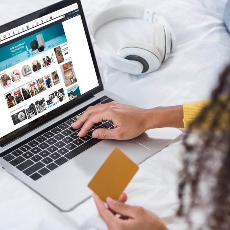 cropped-image-of-woman-holding-credit-card-and-using-laptop-with-amazon-on-screen.jpg